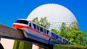 The monorail passing an attraction resembling a giant sphere called 'Spaceship Earth'