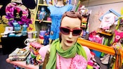 Mannequins dans un magasin portant des lunettes de soleil, écharpes, colliers et t-shirts
