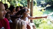 A girl points at animals while riding in a bus full of Guests on Kilimanjaro Safaris