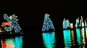 A sea-serpent realized in colorful lights seems to be rising from the waters of Seven Seas Lagoon