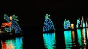 A sea-serpent realized in colorful lights seems to be rising from the waters of Seven Seas Lagoon