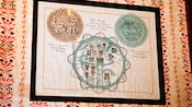 Special maps to Magic Kingdom theme park, framed and hanging on a wallpapered wall