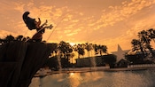 Estátua do Mickey Feiticeiro sobre a Fantasia Pool no Disney’s All-Star Movies Resort ao anoitecer