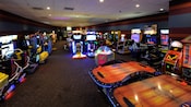 Salle d'arcade d'un hôtel Disney avec jeux vidéo, jeux de course et hockey sur coussin d’air
