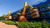 Dos versiones gigantes de las escobas bailarinas con baldes en las manos de Fantasía de Disney adornan el costado de Disney's All-Star Movies Resort