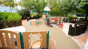 Um playground de areia com aparato para escaladas, escorregadores, redes e trepa-trepa