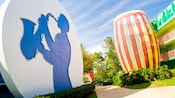 Structure circulaire arborant la silhouette d’un joueur de saxophone au travers d’un chemin venant d’un tambour géant orne le côté du Disney’s All-Star Music Resort