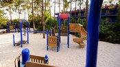 A sandy playground with a climbing apparatus, slide, nets and monkey bars at Disney's All-Star Music Resort