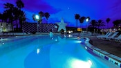 Une piscine éclairée à la tombée de la nuit au Disney’s All-Star Sports Resort
