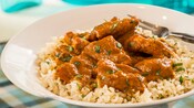 Chicken tikka masala on a bed of rice in a bowl