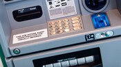 Un guichet automatique avec une enseigne indiquant que la machine offre une assistance audio pour les visiteurs ayant une déficience visuelle