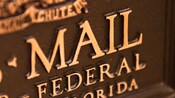 Close-up of the front of a bronze U.S. Mail chute