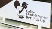 Countertop sign that says 'Online Check-In Service, Key Pick Up'