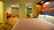 Uma cama no estilo Murphy com uma imagem de Simba acima e, em segundo plano, um quarto e uma sala de estar