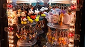 Assorted plush keychains from Mickey Mouse to Winnie the Pooh on a hanging display