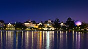 As luzes noturnas do Disney's Beach Club Resort com o brilho lilás da Spaceship Earth no EPCOT
