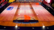 Vista de una mesa de air hockey con 2 paletas anaranjadas