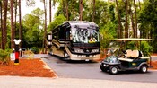 A luxury R V and a golf cart provide comfort in the campground surroundings
