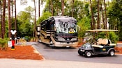 A luxury R V and a golf cart provide comfort in the campground surroundings