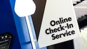 Un letrero, sobresaliendo de una pared, que dice 'Online Check-In Service' (Servicio de check-in en línea)