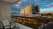 Un balcón de hotel con una silla y una misa con vista al sendero a Disney’s Contemporary Resort