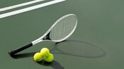 A tennis racquet and 3 tennis balls