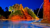 The Mayan pyramid and spouting fountain at the Dig Site pool area, lit up at night