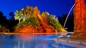 The Mayan pyramid and spouting fountain at the Dig Site pool area, lit up at night