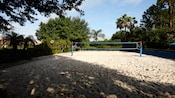 A sandy white volleyball court with a blue net