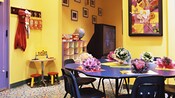 A kid's play room with craft table, toys and a big-screen TV