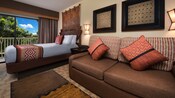 Una mesa ratona, sofá, cuadro, 2 lámparas de pared, cama con cabecera de madera, adorno de pared y balcón
