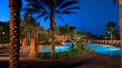 La piscina Samawati Springs Pool de noche, rodeada de palmeras