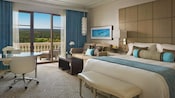 A hotel room with a bed, sofa and balcony overlooking a golf course