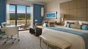Um quarto de hotel com uma cama, sofá e varanda com vista para um campo de golfe