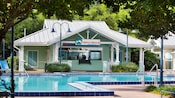 Uma piscina perto de um bar com uma placa em que se lê “Turtle Shack Poolside Snacks”