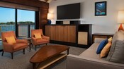 Sala de estar con balcones con vistas espectaculares al agua y elegantes muebles estilo moderno de mitad de siglo