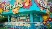 A kiosk with a bar, chairs and a sign that reads Petals