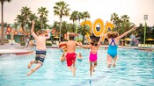 A group of children jump into the Hippy Dippy Pool at Disney’s Pop Century Resort
