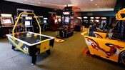 Juegos de hockey de mesa, baloncesto y de carreras de autos en una sala de videojuegos en Disney's Saratoga Springs Resort & Spa