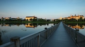 Un puente largo que cruza el lago y conduce a Disney’s Saratoga Springs Resort & Spa