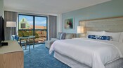 Une chambre à l’hôtel Swan de Walt Disney World comprend un très grand lit, un ameublement contemporain et une vue