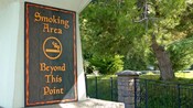 Un panneau extérieur indiquant une zone fumeur (« Smoking Area Beyond This Point »)