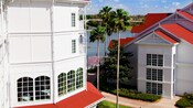 Un chemin passe entre les bâtiments et à côté du Seven Seas Lagoon au Disney’s Grand Floridian Resort & Spa