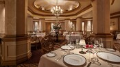 La somptueuse salle à manger du restaurant Victoria and Albert’s avec des tables dressées avec des services en porcelaine raffinés.