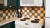 Um fogão, micro-ondas e cafeteira em uma pequena cozinha em uma Villa no Disney's Wilderness Lodge