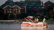 A boat on the water with 3 men fishing in front of Wilderness Lodge Resort