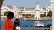 Une femme et un enfant contemplent le lac devant le Disney’s Yacht Club Resort