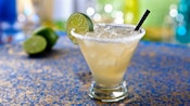 A margarita on the rocks with a lime wedge and salt around the rim of the glass