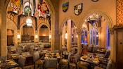 Cinderella’s Royal Table dining area features soaring stone archways and majestic stained-glass windows