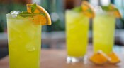 3 boissons glacées ornées d’une tranche d’orange et d’une branche de menthe